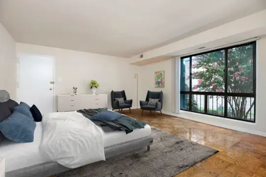 hardwood floored bedroom with a wealth of natural light