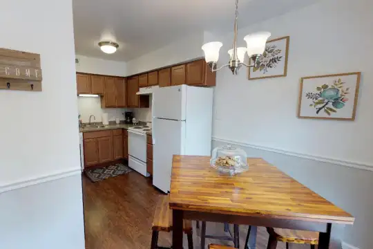 dining space with hardwood floors, range hood, refrigerator, and range oven