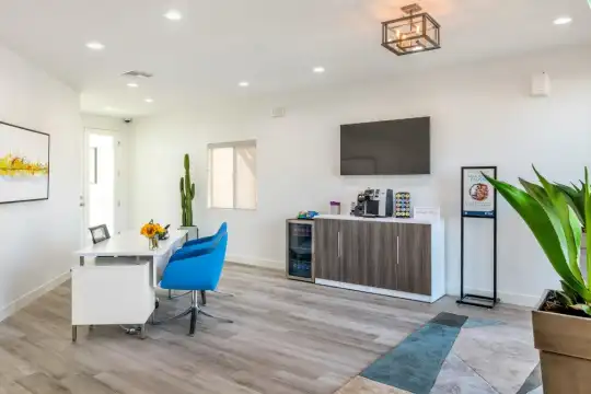 hardwood floored living room with natural light and TV