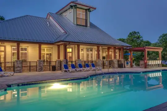 back of property featuring a swimming pool and a pergola