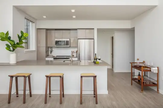 kitchen with stainless steel appliances, range oven, light countertops, light brown cabinets, and light parquet floors