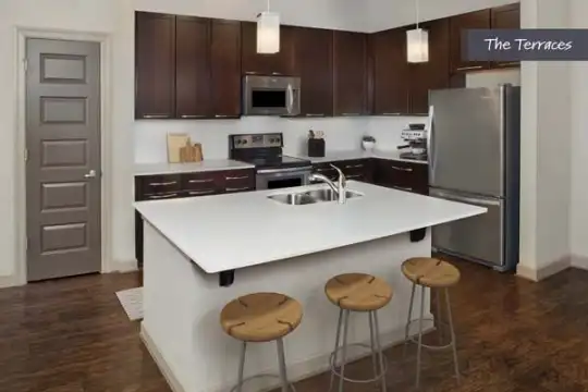 kitchen featuring stainless steel appliances, range oven, dark parquet floors, light countertops, pendant lighting, and dark brown cabinets
