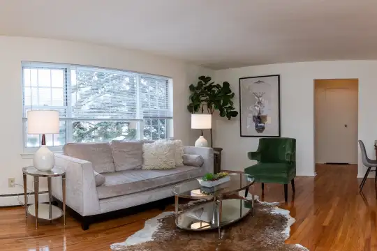living room featuring natural light, hardwood flooring, and baseboard radiator