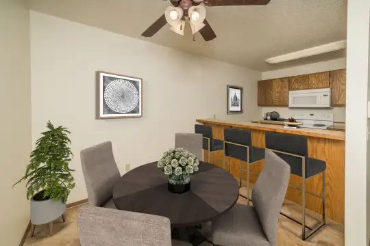 dining space with a ceiling fan, a breakfast bar, and microwave