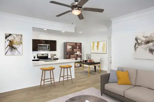 hardwood floored living room with a ceiling fan, a breakfast bar, stainless steel microwave, and range oven