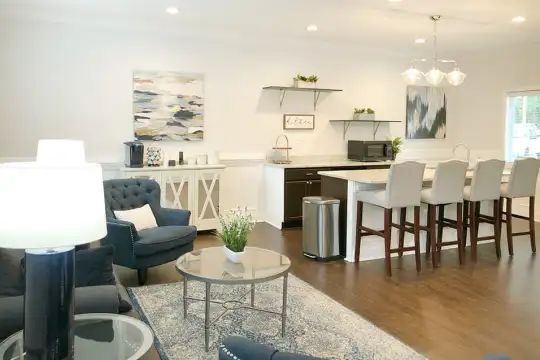 living room with a kitchen bar, hardwood floors, and microwave