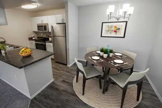 kitchen featuring a center island, stainless steel microwave, refrigerator, electric range oven, dark stone countertops, white cabinetry, and light hardwood flooring