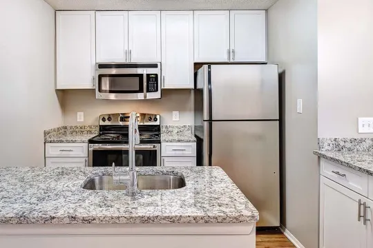 kitchen featuring stainless steel microwave, refrigerator, electric range oven, light floors, white cabinets, and light stone countertops