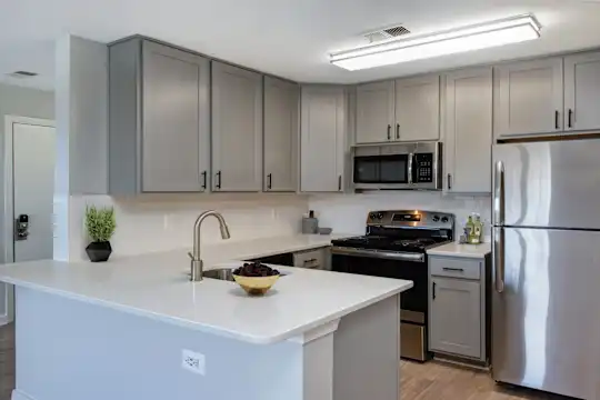 kitchen featuring a center island, stainless steel appliances, electric range oven, white cabinetry, light parquet floors, and light granite-like countertops