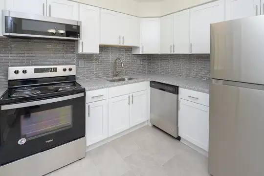 kitchen featuring stainless steel appliances, electric range oven, light tile flooring, white cabinets, and light stone countertops
