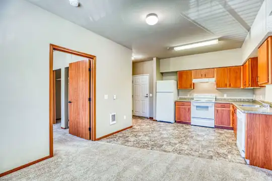 kitchen featuring carpet, refrigerator, electric range oven, dishwasher, exhaust hood, light flooring, light countertops, and brown cabinetry