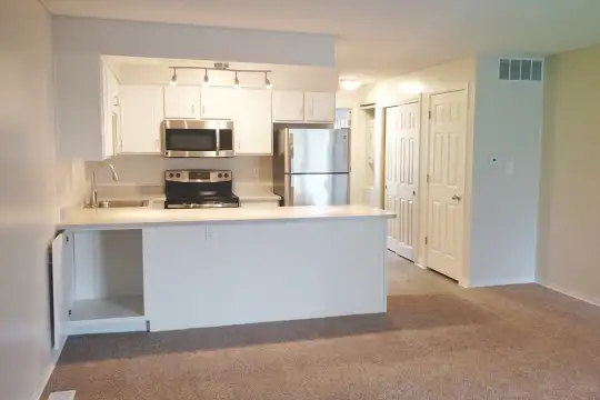 kitchen with carpet, stainless steel appliances, range oven, white cabinetry, light floors, and light countertops