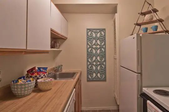 kitchen with refrigerator, dishwasher, dark countertops, light flooring, and white cabinets
