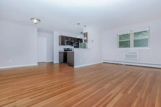 hardwood floored living room featuring natural light, baseboard radiator, and microwave