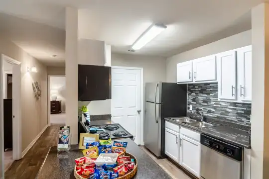 kitchen featuring TV, refrigerator, stainless steel dishwasher, white cabinets, dark parquet floors, and dark granite-like countertops