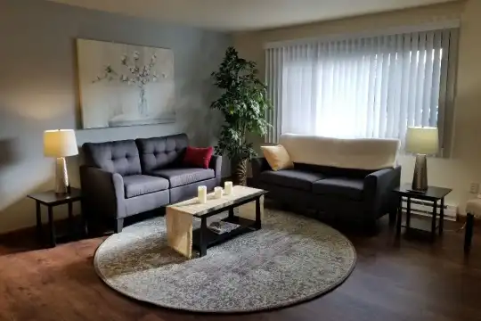 living area with hardwood flooring, plenty of natural light, and baseboard radiator