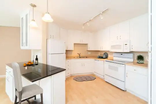 kitchen featuring refrigerator, dishwasher, electric range oven, microwave, white cabinetry, light hardwood flooring, and pendant lighting
