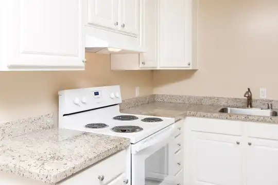 kitchen with electric range oven, fume extractor, white cabinetry, and light stone countertops