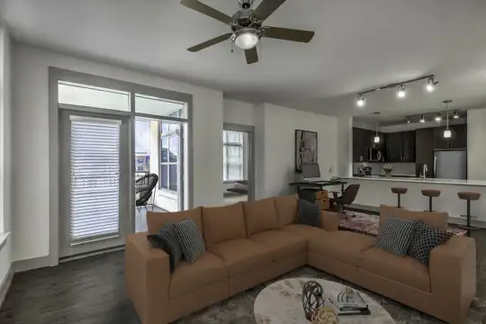 hardwood floored living room featuring a healthy amount of sunlight, a ceiling fan, french doors, a breakfast bar, and refrigerator