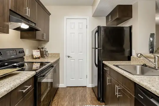 kitchen with electric range oven, exhaust hood, refrigerator, dishwasher, dark parquet floors, light stone countertops, and dark brown cabinets