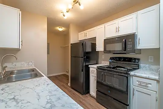 kitchen featuring refrigerator, electric range oven, microwave, light granite-like countertops, white cabinetry, and light parquet floors