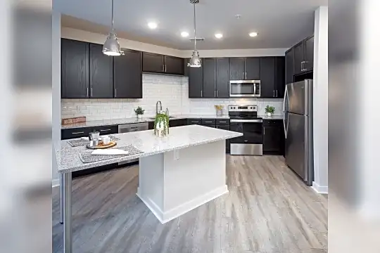 kitchen with stainless steel appliances, range oven, granite-like countertops, dark brown cabinetry, pendant lighting, and light parquet floors