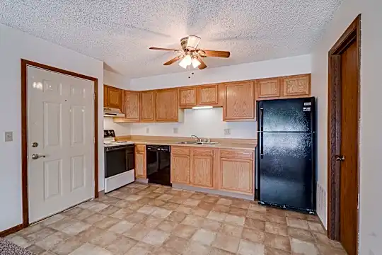 kitchen with a ceiling fan, electric range oven, refrigerator, dishwasher, fume extractor, light tile floors, brown cabinets, and light countertops