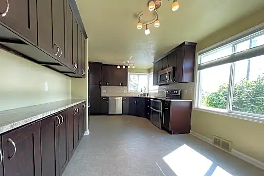 Kitchen with stainless steel appliances and granite countertops, natural light