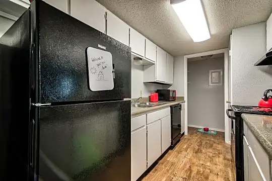 kitchen featuring range oven, refrigerator, dishwasher, microwave, dark hardwood floors, white cabinetry, and light granite-like countertops