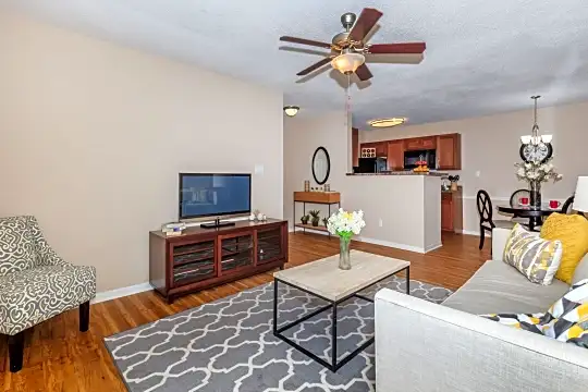 hardwood floored living room featuring a ceiling fan, TV, and microwave