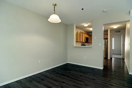 wood floored spare room featuring refrigerator and microwave