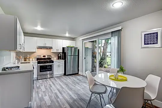 kitchen featuring gas range oven, stainless steel refrigerator, fume extractor, light floors, light countertops, and white cabinets