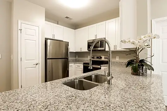 kitchen featuring electric range oven, stainless steel appliances, light stone countertops, and white cabinets