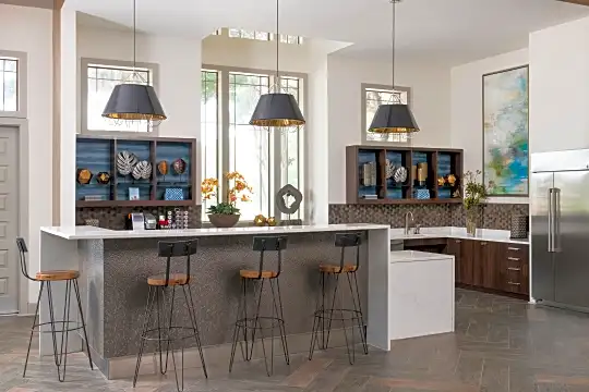 kitchen featuring natural light, a kitchen breakfast bar, stainless steel refrigerator, light hardwood flooring, pendant lighting, and dark brown cabinetry