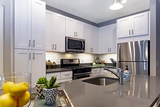kitchen featuring stainless steel appliances, gas range oven, white cabinetry, and light flooring