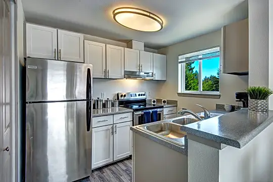 kitchen featuring natural light, stainless steel refrigerator, ventilation hood, electric range oven, white cabinetry, light flooring, and dark stone countertops