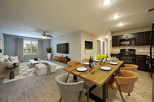 hardwood floored dining space with natural light, a ceiling fan, range oven, TV, and microwave