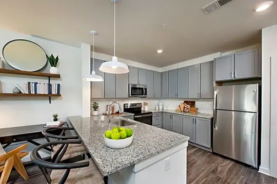 kitchen featuring a kitchen bar, stainless steel refrigerator, range oven, microwave, dark parquet floors, pendant lighting, white cabinetry, and light stone countertops
