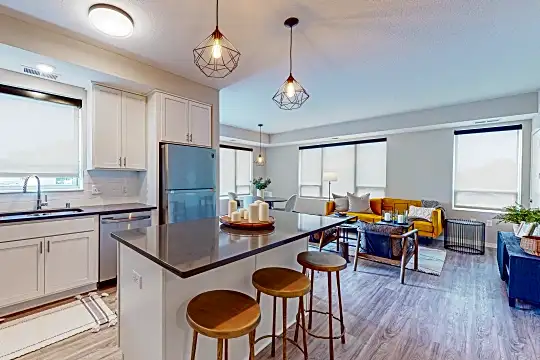 kitchen featuring a breakfast bar area, refrigerator, stainless steel dishwasher, dark countertops, pendant lighting, light parquet floors, and white cabinets