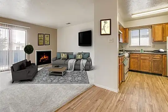 living room with a fireplace, natural light, hardwood flooring, refrigerator, TV, and range oven