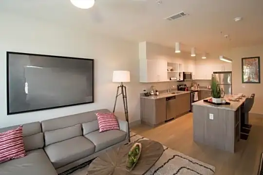hardwood floored living room featuring a kitchen island, a ceiling fan, range oven, refrigerator, dishwasher, and microwave