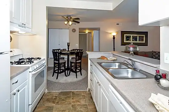 kitchen with a ceiling fan, refrigerator, gas range oven, dishwasher, fume extractor, light tile floors, white cabinets, and light countertops