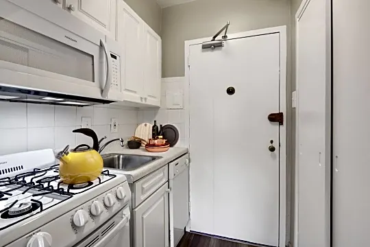 kitchen featuring dishwasher, microwave, dark floors, white cabinetry, and light countertops