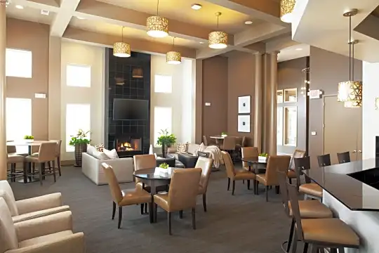 community lobby featuring carpet, natural light, a fireplace, wood beam ceiling, a breakfast bar area, and TV