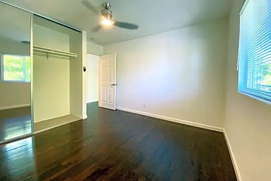 hardwood floored bedroom with natural light
