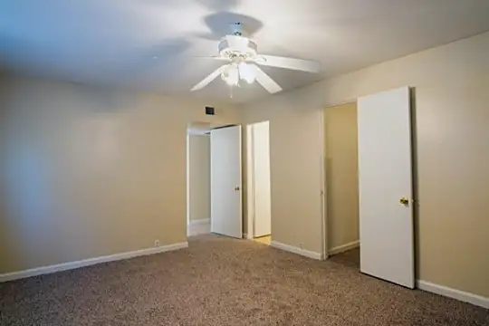 empty room featuring a ceiling fan and carpet