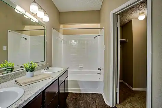 bathroom with shower / bathtub combination, dual vanity, and mirror