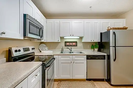 kitchen featuring stainless steel appliances, electric range oven, white cabinetry, light floors, and light countertops
