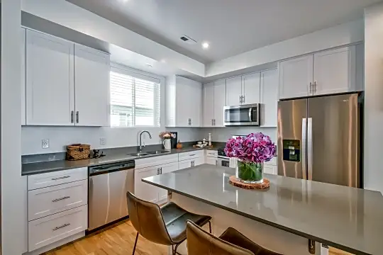 kitchen featuring natural light, stainless steel appliances, white cabinetry, and light parquet floors