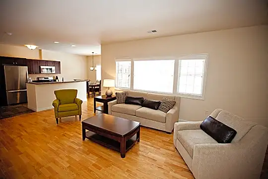 living room with hardwood floors, natural light, stainless steel refrigerator, and microwave
